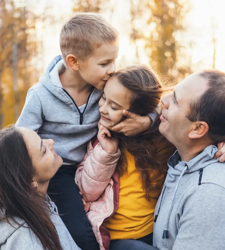 Happy family playing outdoors, parents with child in nature